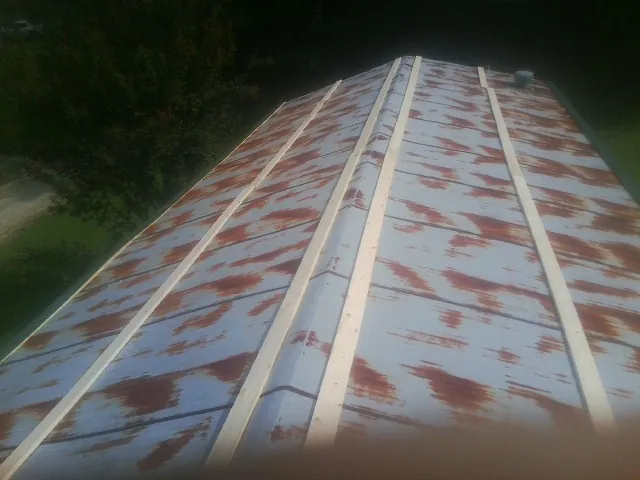 Rusted metal roof panels with new wood purlins before replacement — Storm Damage Roof Repair in Martville by Roofing Brothers