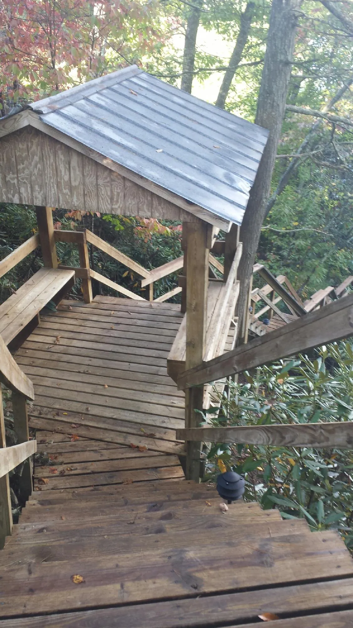 Metal roofed shelter over wooden steps on a wooded walkway — Skylight Repair & Installation work by our crew in Martville