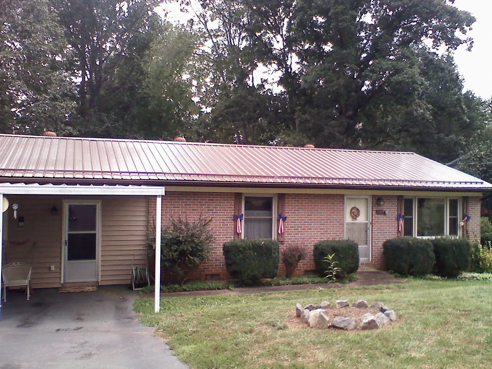 Bronze metal roof and carport on a brick ranch home — Roof Repair work by our crew in Martville